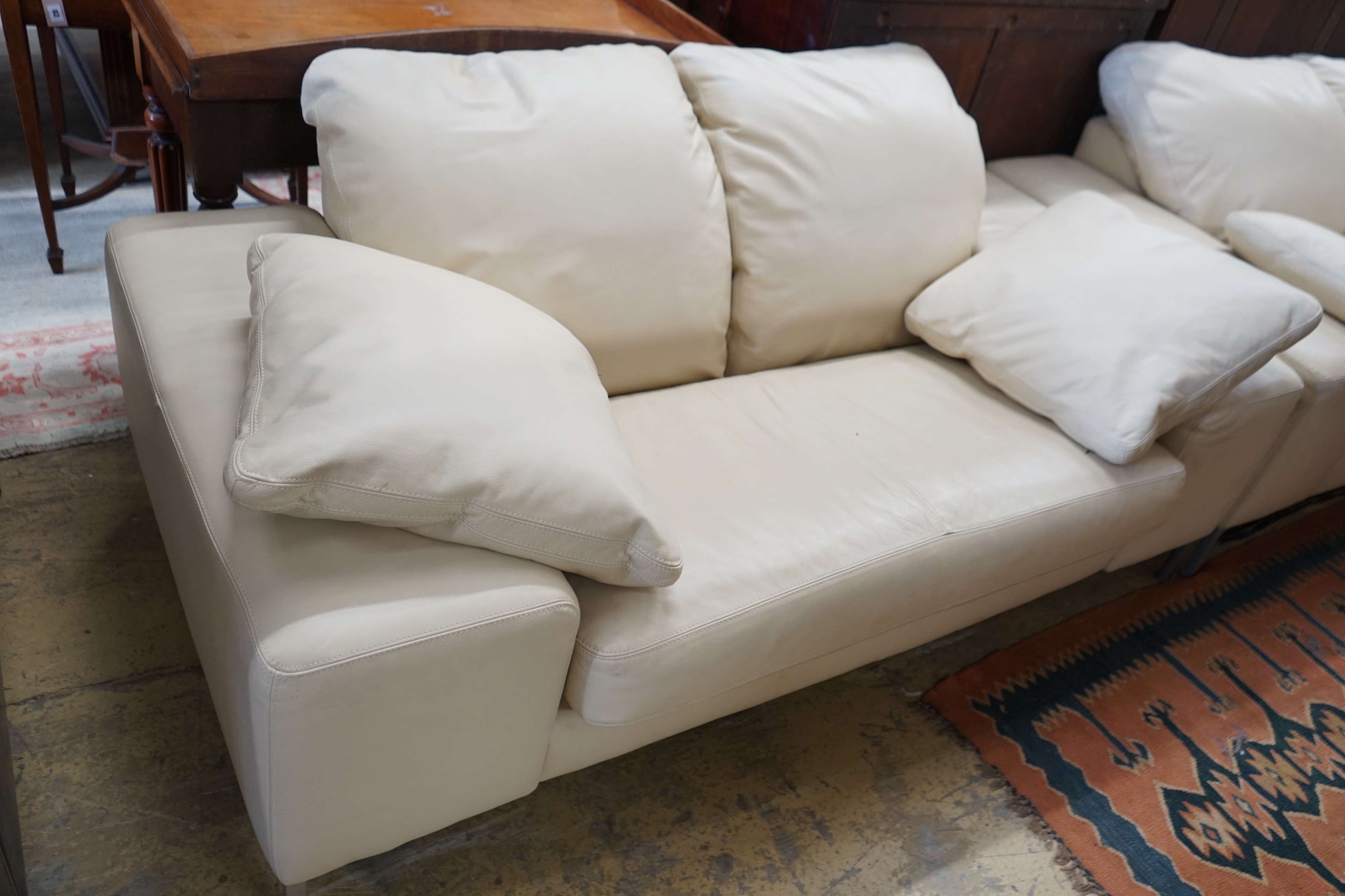 A contemporary Italian design cream leather three seater and two seater settee, larger length 210cm, depth 96cm, height 80cm